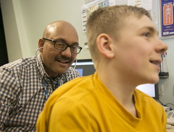 Prof Somnath Mukhopadhyay with a patient in a yellow tshirt assessing asthma