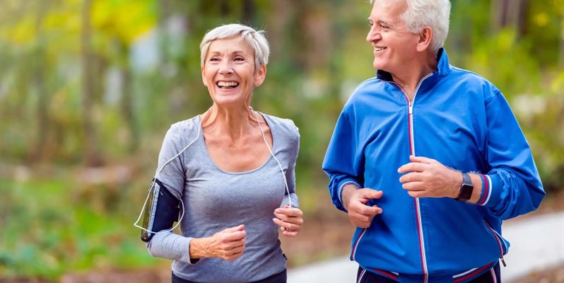Two older people running together outside