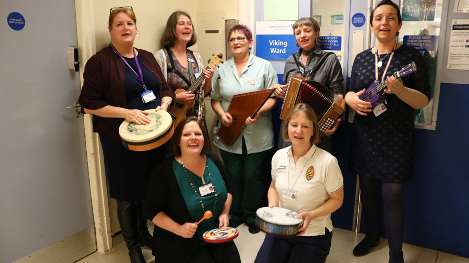 A music therapy group from the team playing various different instruments and singing on a hospital ward