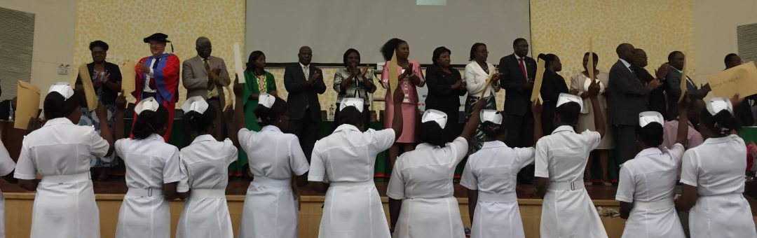 nurses raising their hands on a stage in Zambia