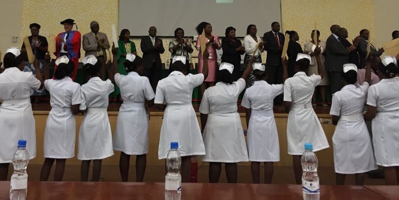 nurses raising their hands on a stage in Zambia