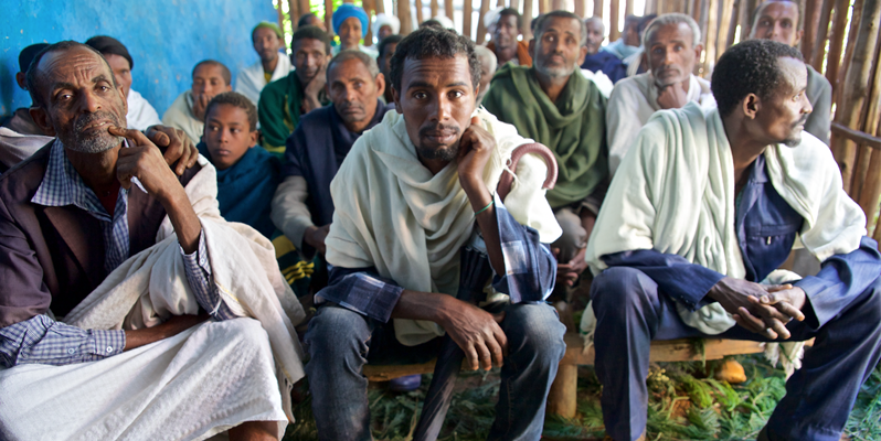 Three men in a medical centre waiting room. Image credited to Alex Kumar