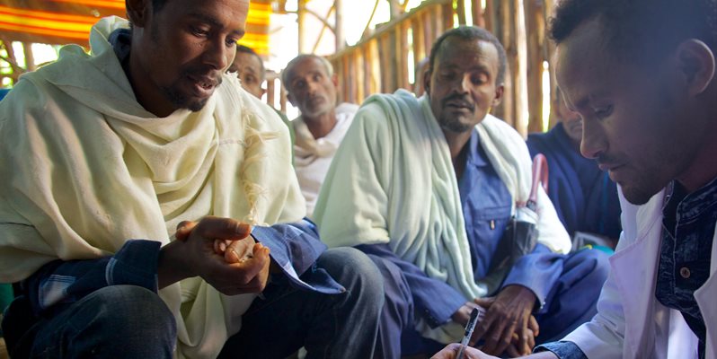 Three men in robes in a health centre in Ethiopia. Image credited to Alex Kumar