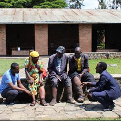 A group of people sitting together on a wall in Rwanda