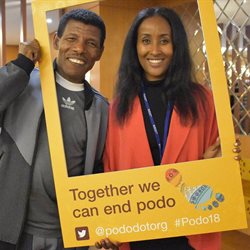 Two people standing inside a selfie frame at the first international podo conference