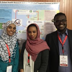 3 phd students in front of a poster