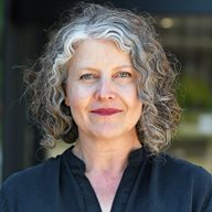 A woman named Alison Smith stood in front of a building smiling at the camera