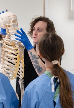 A photo of Dr Ash O'brien teaching students in the anatomy suite