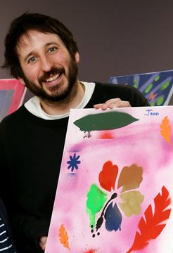 Ben Hicks holding a painting as part of his dementia research