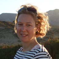 A photo of BSMS staff member Elizabeth Ford standing with mountains in the background on a sunny day