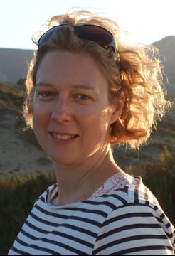 A photo of BSMS staff member Elizabeth Ford standing with mountains in the background on a sunny day