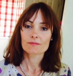 Emma Fox head and shoulder image photographed in front of checkered curtains