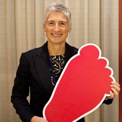 Gail Davey holding a large cardboard foot