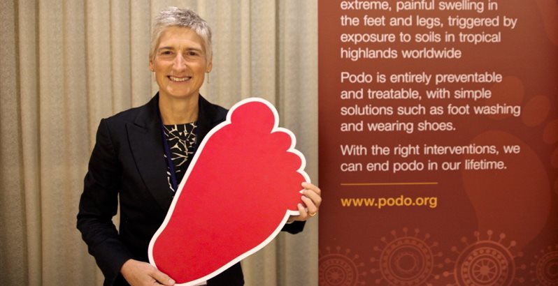Gail Davey pictured holding a cardboard foot at a podoconiosis conference in Ethiopia 