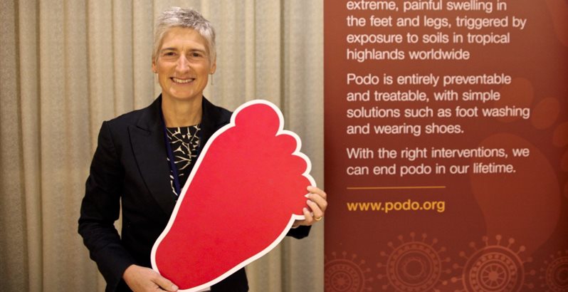Gail Davey pictured holding a cardboard foot at a podoconiosis conference in Ethiopia