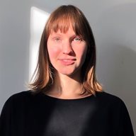 A head and shoulders photo of Gerda Prakopimaite, a research fellow, in a black jumper in front of a white wall