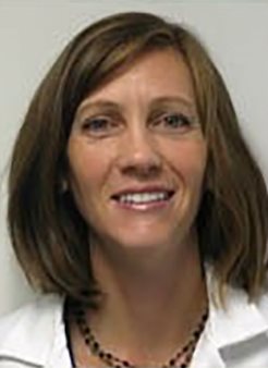 Karen Patterson pictured in a white shirt, smiling against a grey wall