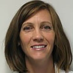 Karen Patterson pictured in a white shirt, smiling against a grey wall