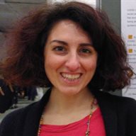 A profile photo of Lavinia Bertini, wearing a black and pink top next to a poster on a display board