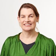 A head and shoulders image of Lisa Page in a green top in front of a white wall