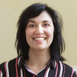 A head and shoulders photo of BSMS staff member Neena Shukla Morris in front of a cream wall