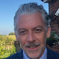 Peter Studley photographed outside a building on a sunny day