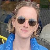 Student sitting outside on a chair with legs crossed