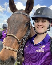 Rebecca Webster profile photo standing next to a horse