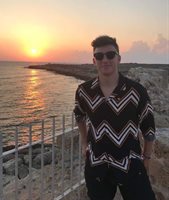 BSMS student Oli Reigler photographed with sunglasses in front of a sunset at the beach