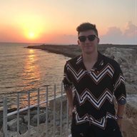 BSMS student Oli Reigler photographed with sunglasses in front of a sunset at the beach