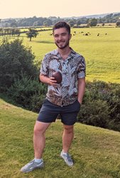 BSMS student Ollie Pentz pictured in a green field with trees wearing a shirt and shorts